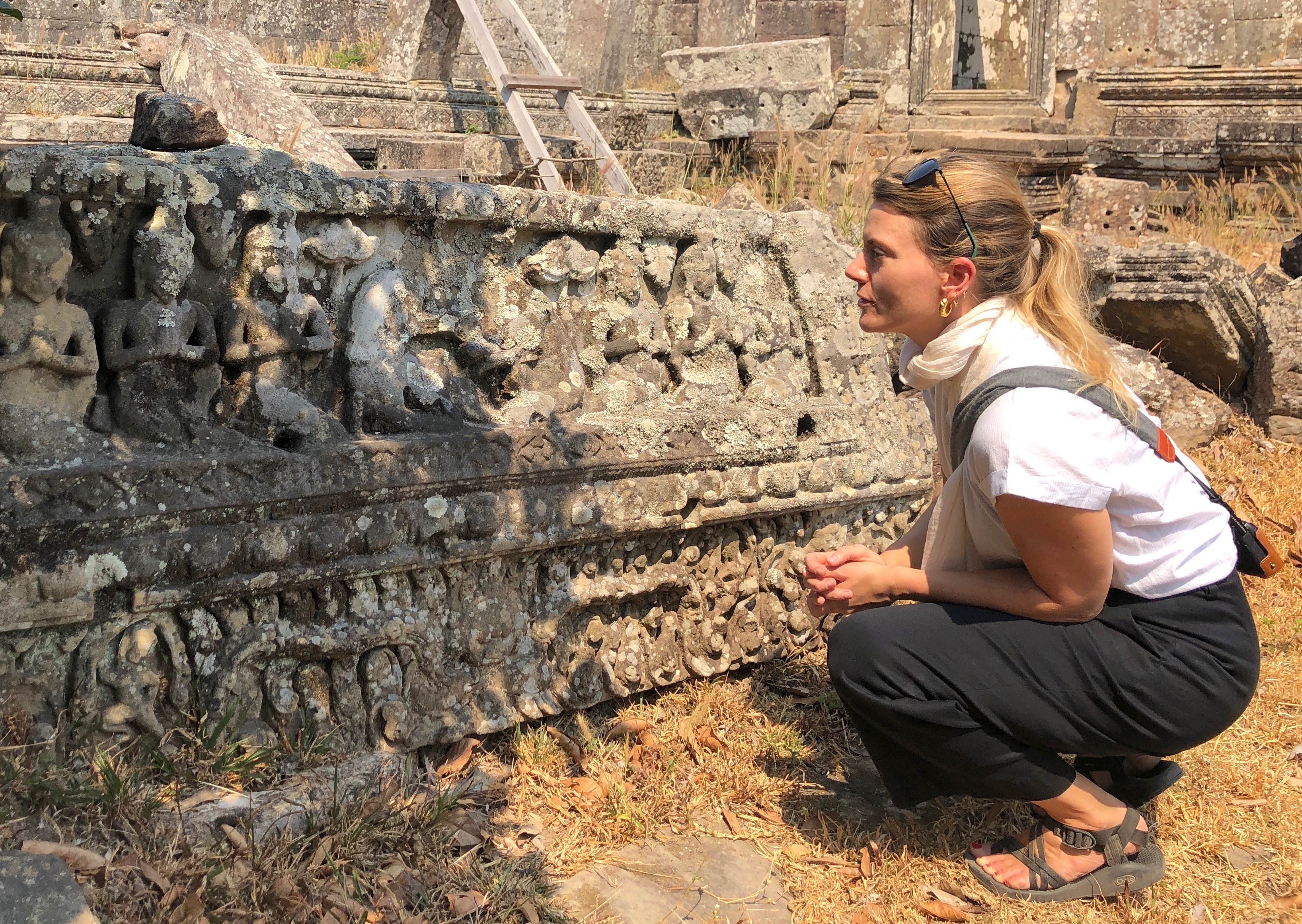 Assistant professor of religion at FSU Elizabeth Cecil crouches and analyzes an artifact.