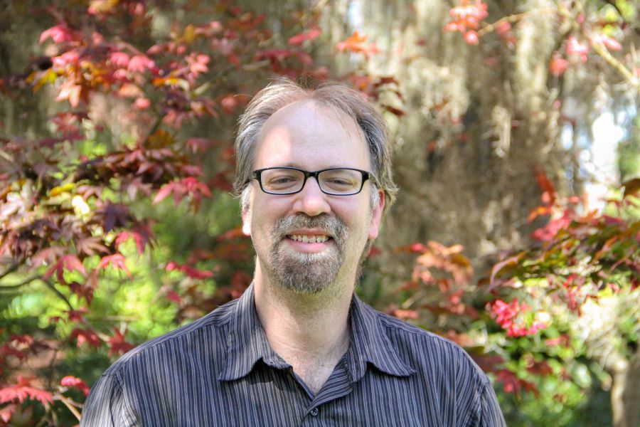 This is a headshot of Paul Anthony in front of some trees. 