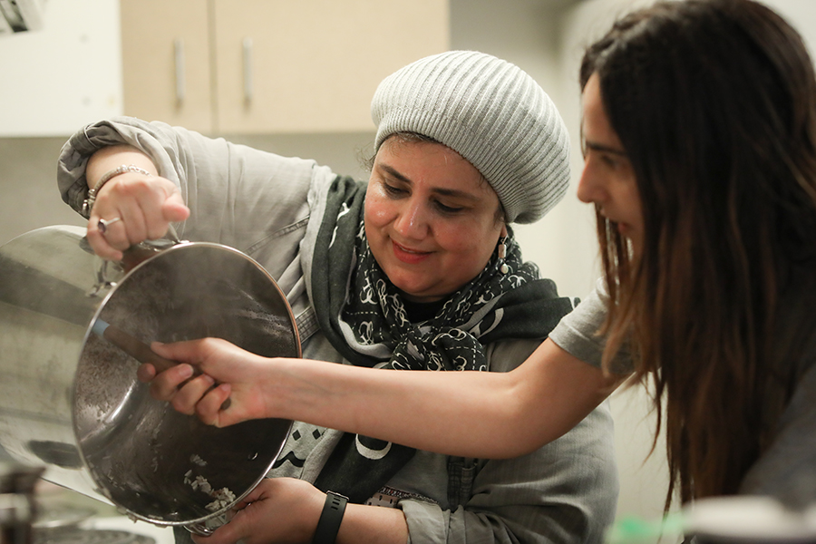 Fulbright foreign language teaching assistant Mais Nassar helps an FSU Arabic Language House resident with food preparation. Photo by Devin Bittner.