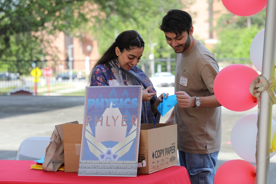Physics doctoral students Mehak Ghafoor (left) and Ahmad Raza (right) set up this year's Circus of Physics' paper airplane contest and are just a few of the many undergraduate and graduate students who helped make the event a success. Photo by Kendall Cooper.