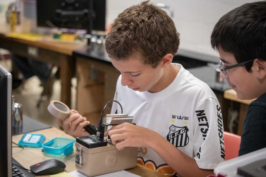 Middle school students use Geiger counters, a device for measuring the presence and frequency of radiation, to study how gamma rays are adsorbed in a variety of materials. Photo by Devin Bittner.