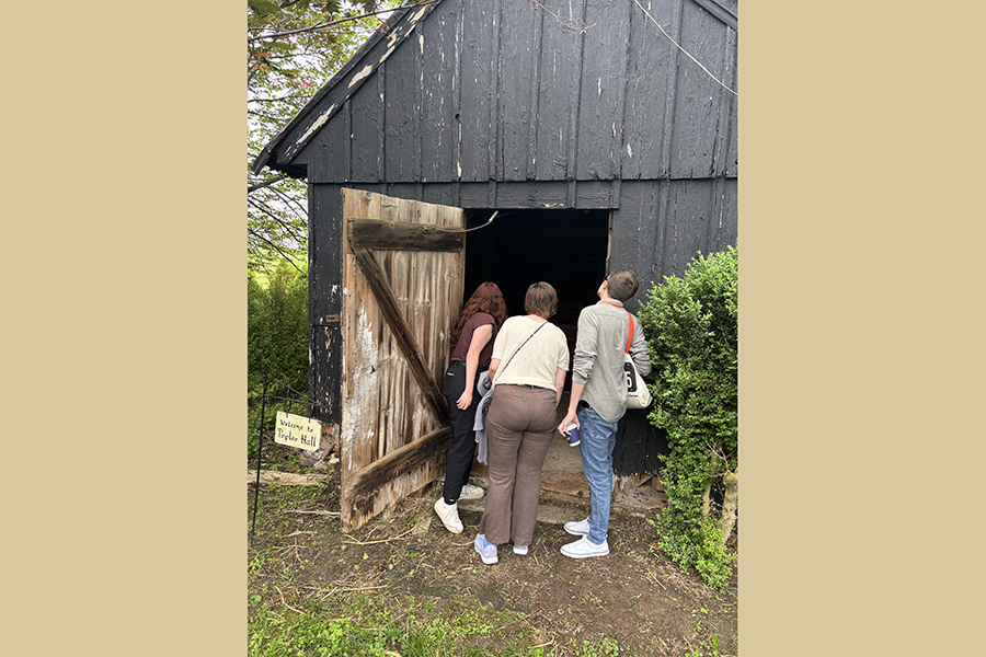 Camp, Evans, and MacKinlay examine an outbuilding at Poplar Hall, Delaware, as part of site visits related to the Vernacular Architecture Forum annual conference in May 2025. Courtesy Photo.