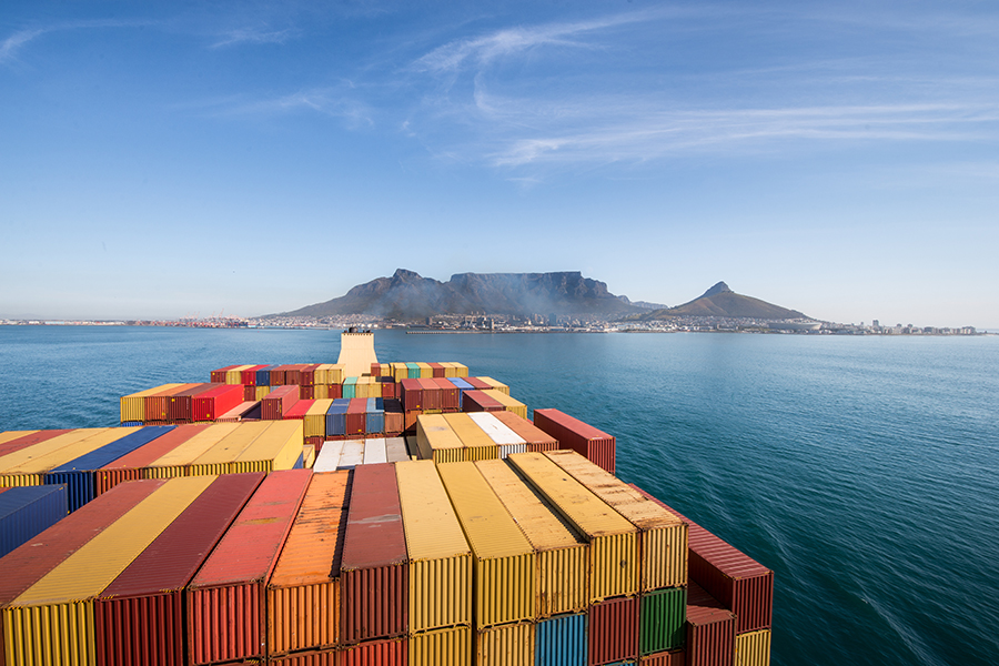 A large stacked container ship leaving the port of Cape Town, South Africa with Table Mountain and the city in the background. (Adobe Stock)