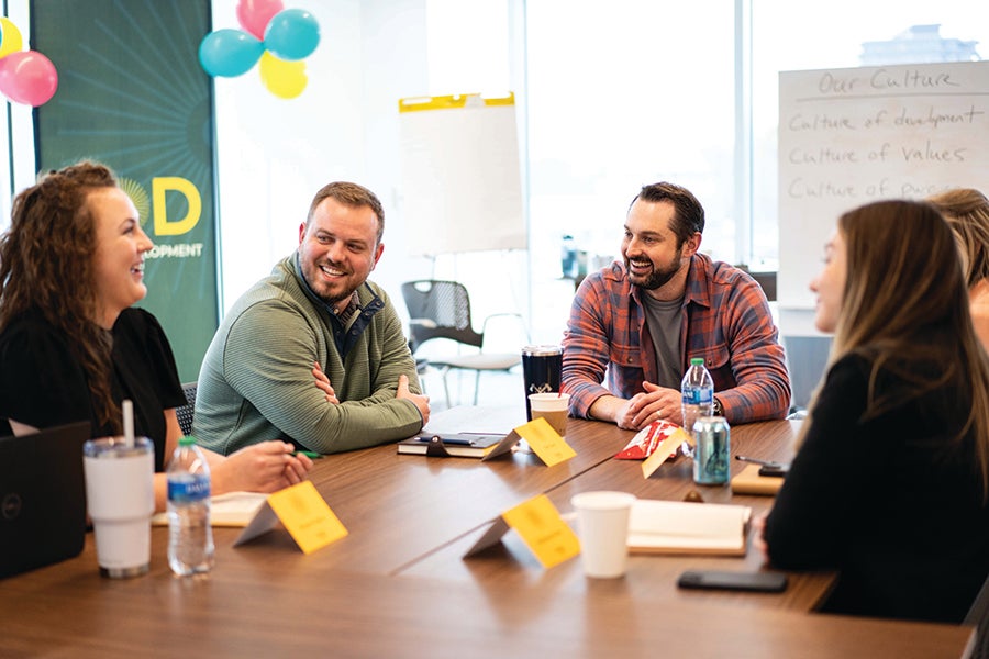 Tim Stutz speaks with colleagues. Photo courtesy Insight Global.