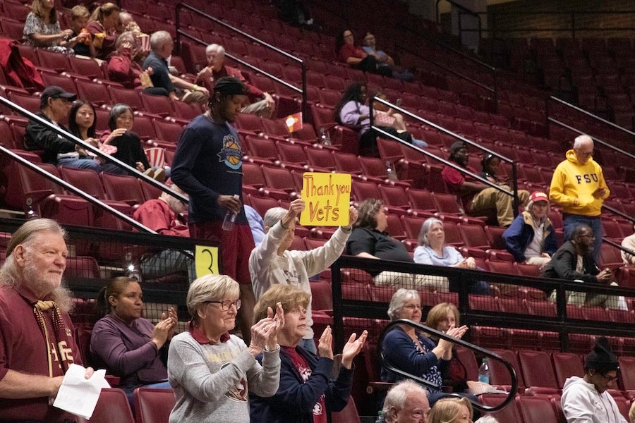 A fan holds a sign reading "Thank you, vets" during an FSU Army ROTC rappelling demonstration at the FSU Women's Basketball game on Feb. 19, 2026 at the Donald L. Tucker Civic Center in Tallahassee, Florida. Photo by Éabha Phelan.