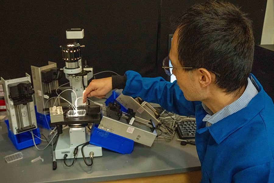 FSU chemistry professor Xiangpeng Li with his microfluidics system for droplet screening