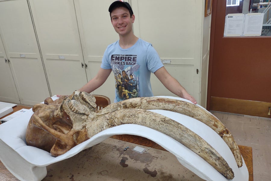 FSU geology doctoral student Chance Hannold with a pygmy mammoth skull at the Natural History Museum of Los Angeles County in Fall 2021