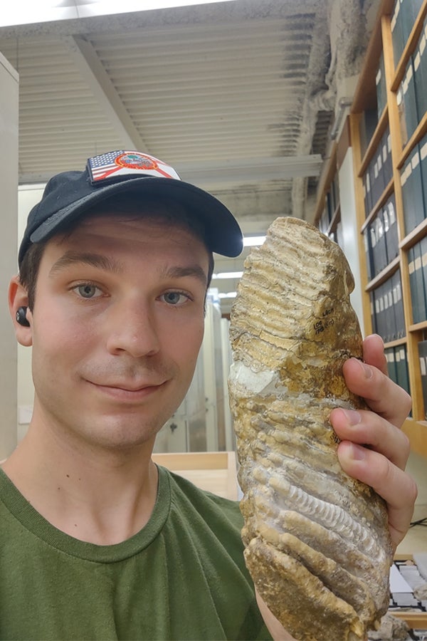 FSU geology doctoral student Chance Hannold with a pygmy mammoth tooth at the Natural History Museum of Los Angeles County in Fall 2021