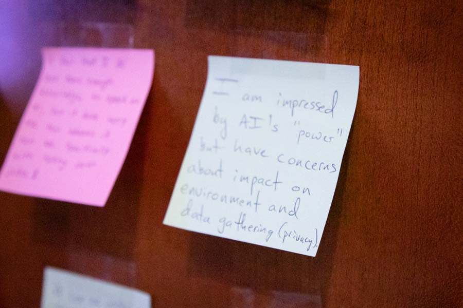 Attendees at the 2026 AI Bootcamp place sticky notes sharing thoughts about AI. Photo by Devin Bittner.