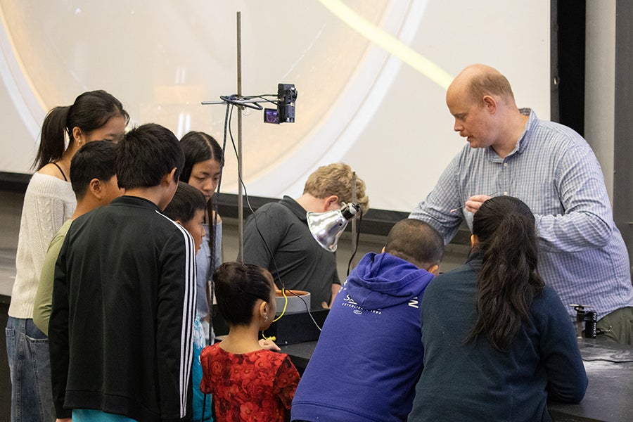 A group of students gather around a desk for a demonstration during a Saturday Morning Physics event at Florida State University on Oct. 18, 2025. Photo by Carly Nelson.