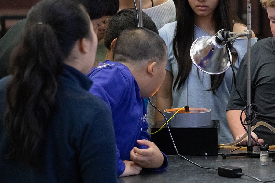 A group of students gather around a desk for a demonstration during a Saturday Morning Physics event at Florida State University on Oct. 18, 2025. Photo by Carly Nelson.
