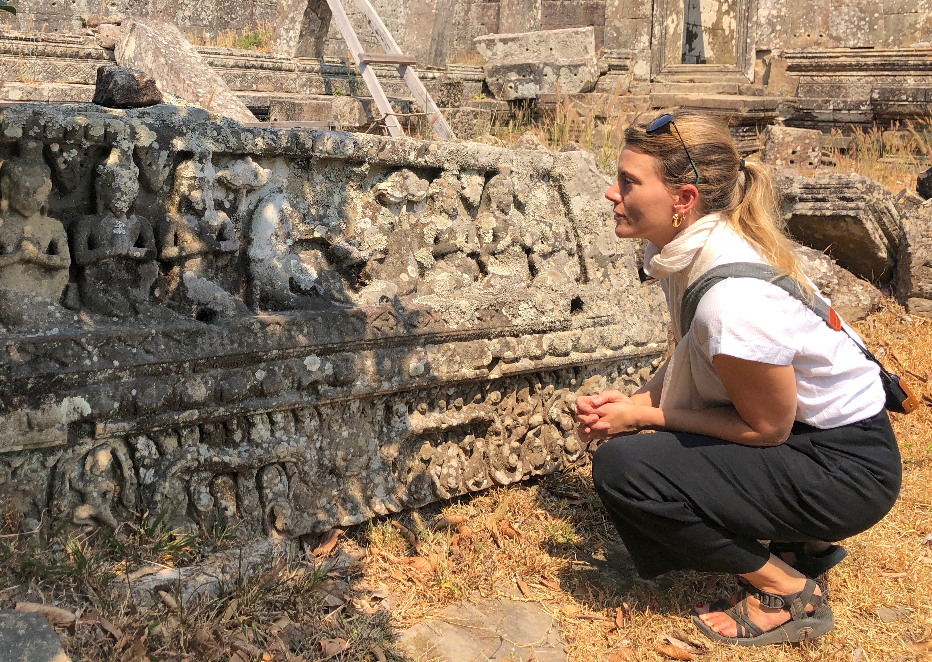 Assistant professor of religion at FSU Elizabeth Cecil crouches and analyzes an artifact. 