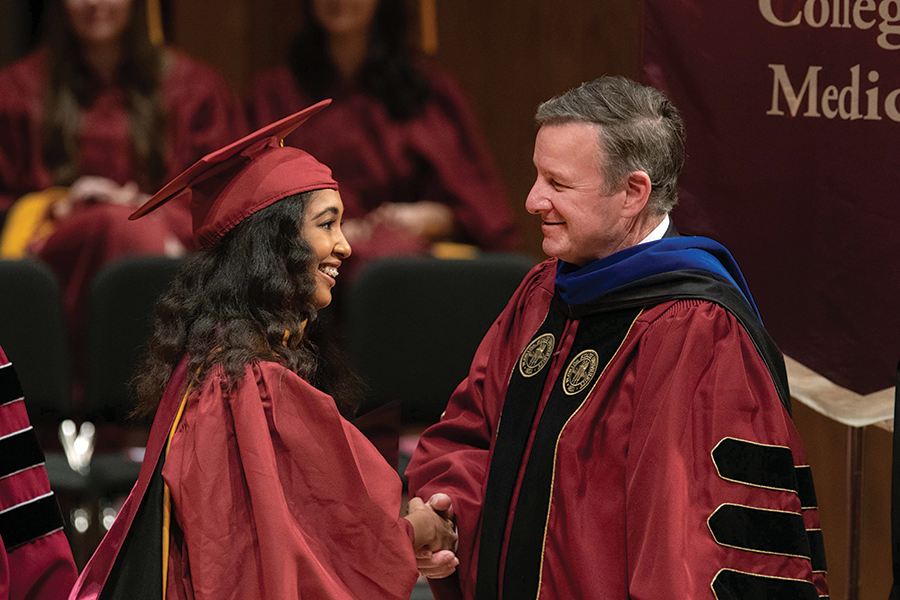 President Richard McCullough congratulates a student during Spring 2022 commencement. Below: McCullough meets with orientation leaders on the first day of the Fall 2021 semester.