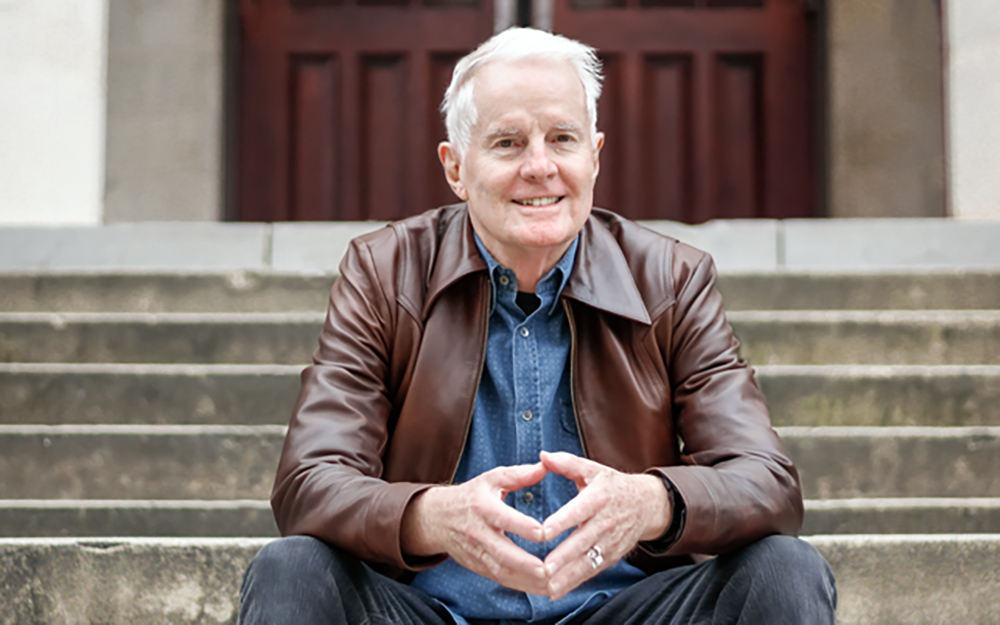 David Kirby sitting on concrete stairs. 