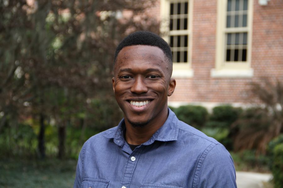 This is a headshot of Jackson Powell smiling in a blue shirt. 