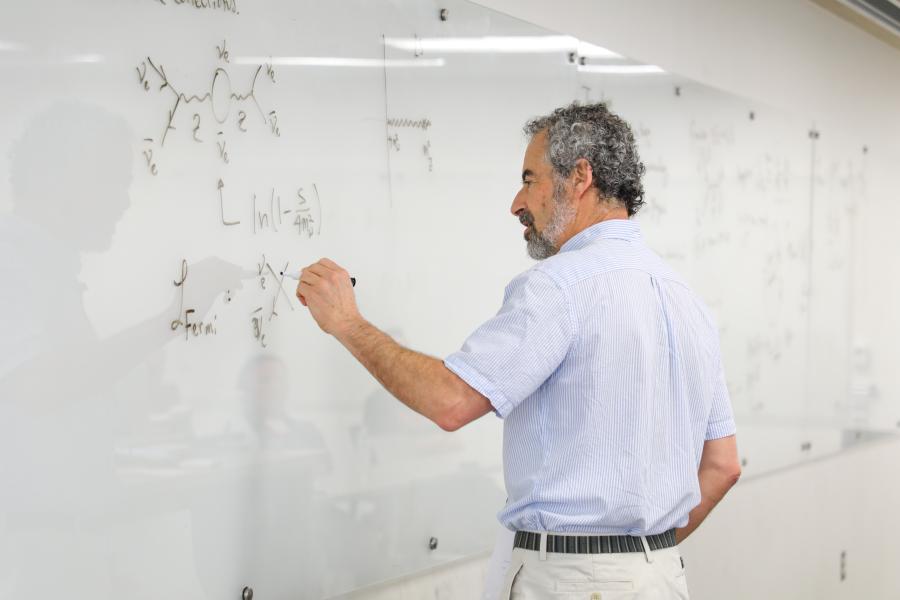 This is a photo of David B. Kaplan writing on a dry erase board.