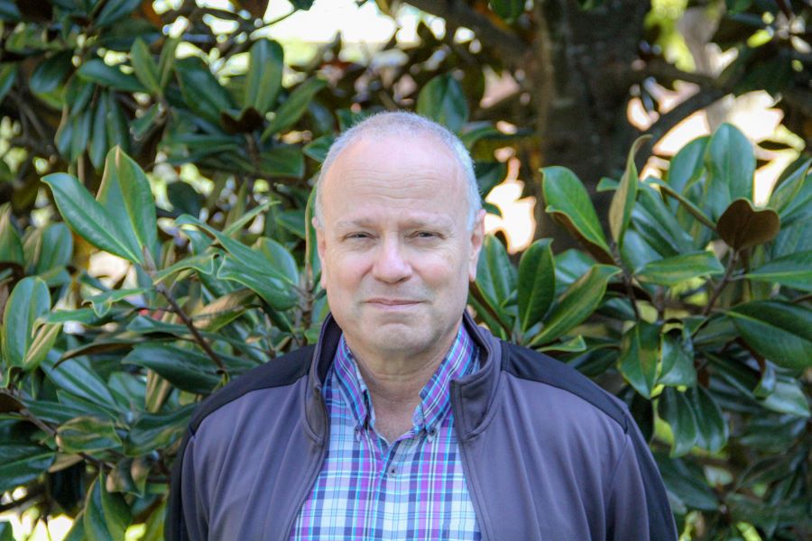 This is a photo of Dr. David Whalley standing in front of some greenery. 