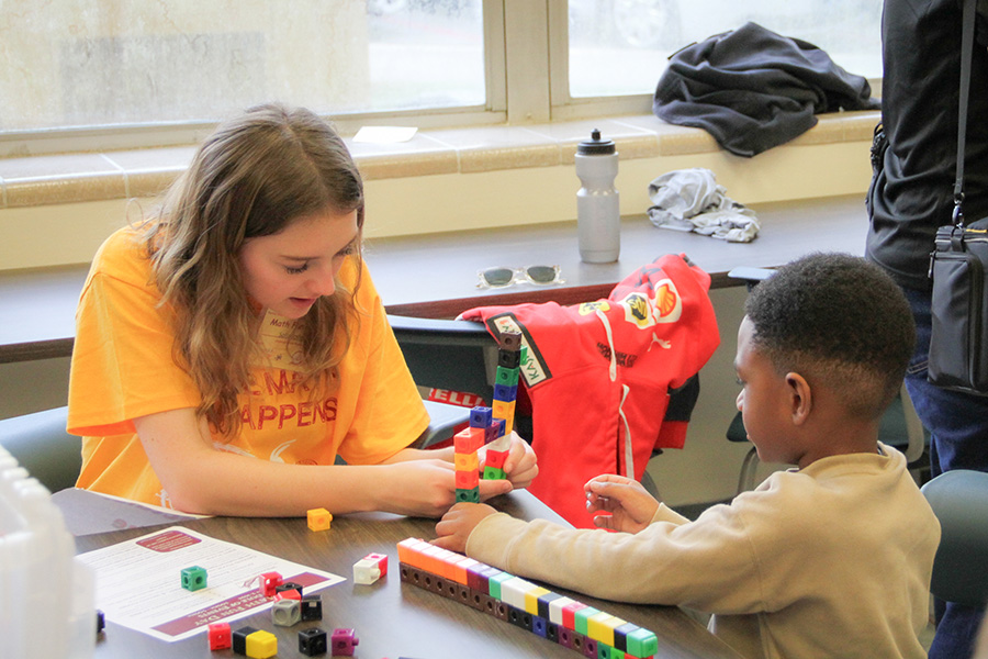 An FSU student helps a Math Fun Day attendee. (Meredith Breen/College of Arts and Sciences)