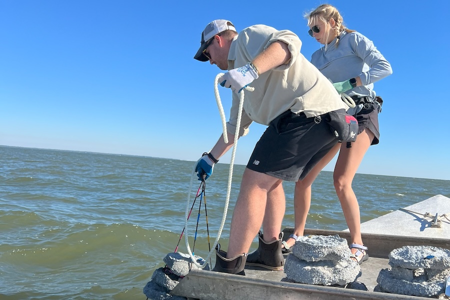 Former lead research technician at FSU's Coastal and Marine Laboratory Rand Ramos (left) and FSU doctoral student Lillie Bradshaw (right) deploy "layer cakes," a type of small artificial reef structure. This work is part of CML's Apalachicola Bay System Initiative, which facilitates research to inform sustainable management and restoration methods following the bay's oyster fishery collapse in the early 2010s. Photo by Shannon Murphy.